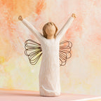 Willow Tree Courage, 6”h hand-painted standing resin angel figure in cream dress with wire wings, both arms upraised, in front of orange painting