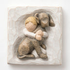 Close up of carved white square stone - in the middle is faceless young boy holding larger brown dog