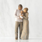Front view of standing couple, woman has lighter skin and hair; man has darker skin and hair, holding a baby between them.