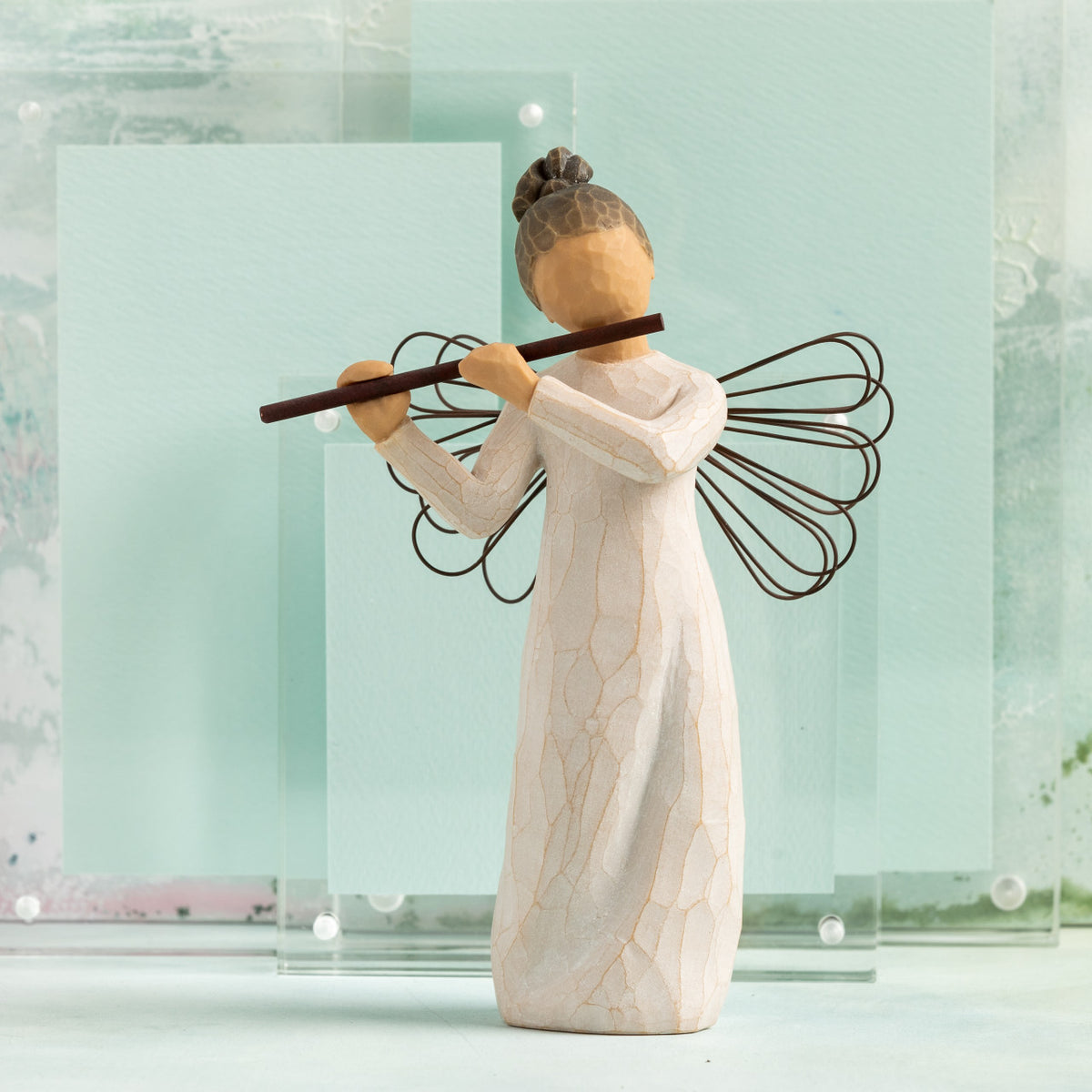 Willow Tree Angel of Harmony, 6"h hand-painted standing resin figure in cream dress with wire wings, playing the flute, in front of celedon painting