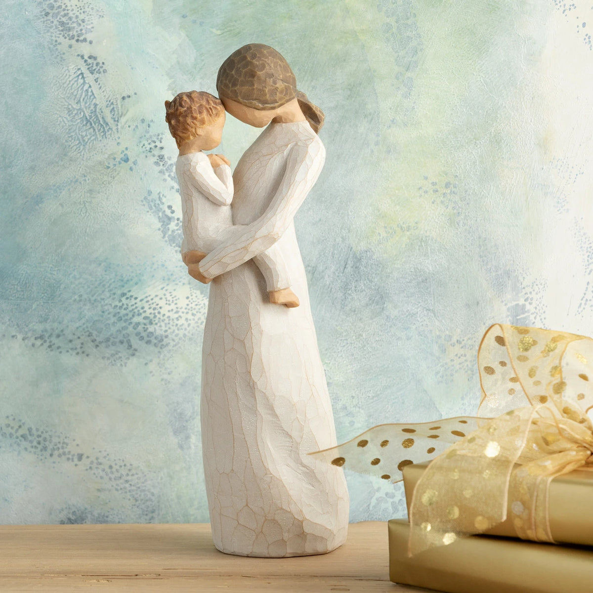 Willow Tree Tenderness, 8”h hand-painted standing resin figure holding toddler, foreheads touching, both dressed in cream, in front of blue painting