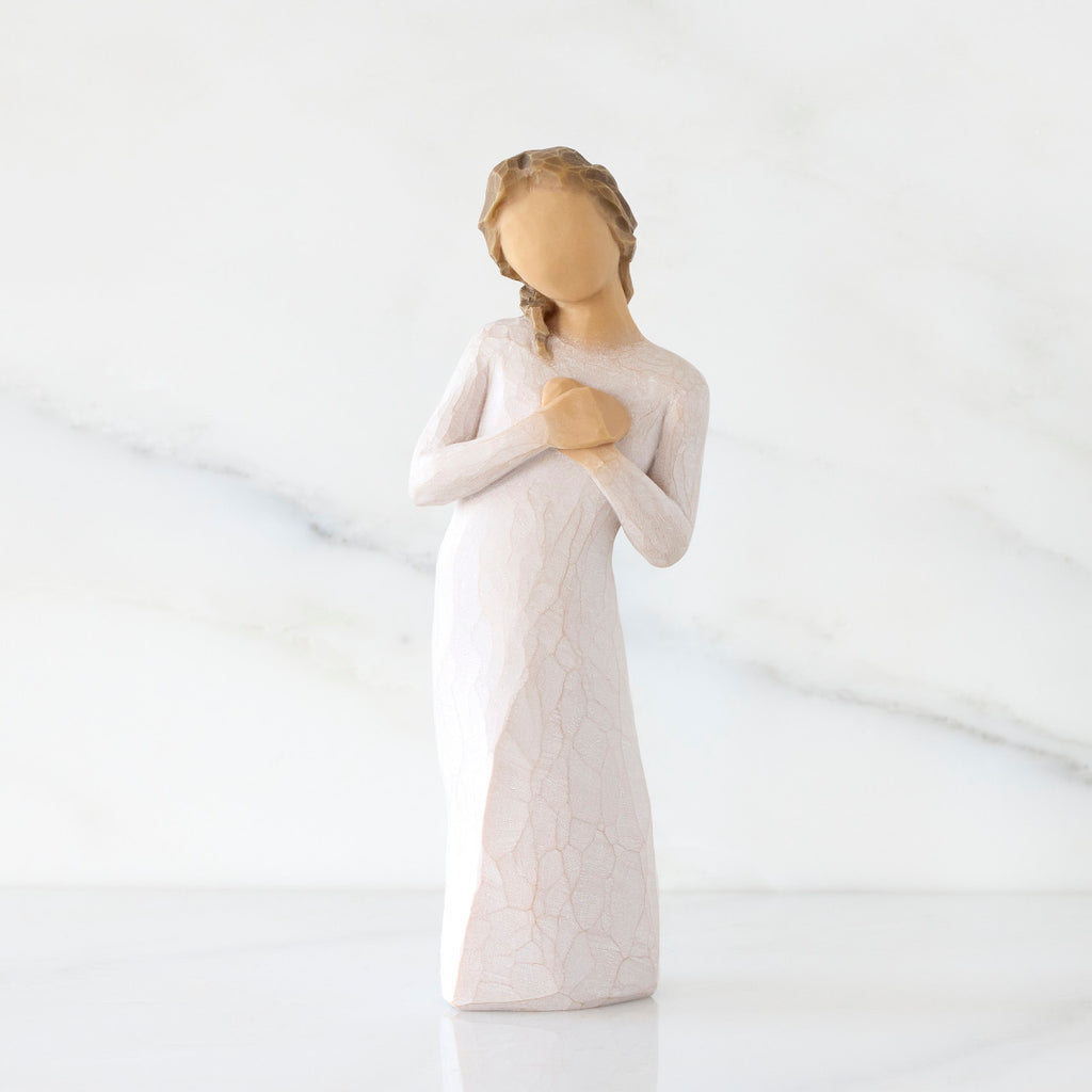 Front view: Standing figure in cream dress with hands to heart in empathetic gesture