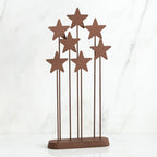 Set of standing brown star figurines on wooden plaque