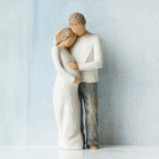 Willow Tree Home, 8.5”h hand-painted standing figure of man and pregnant woman embracing, both in neutral clothes, in front of grey blue painting