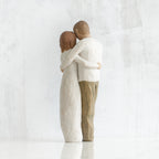 Man and woman figurines - back view - hugging another
