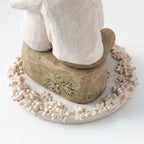 Close view of round white plaque with golden rock on top