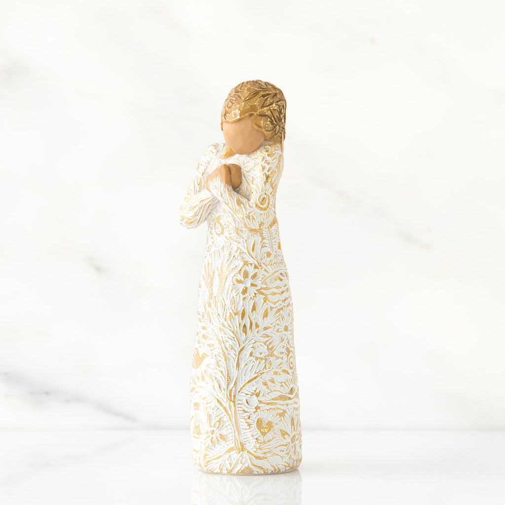 Gold haired woman in white/gold dress facing forward with arms to her chest