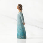 Left profile: Darker-skin figure, arms clasped behind back, hair and deep blue ombré garment dotted with gold leaf