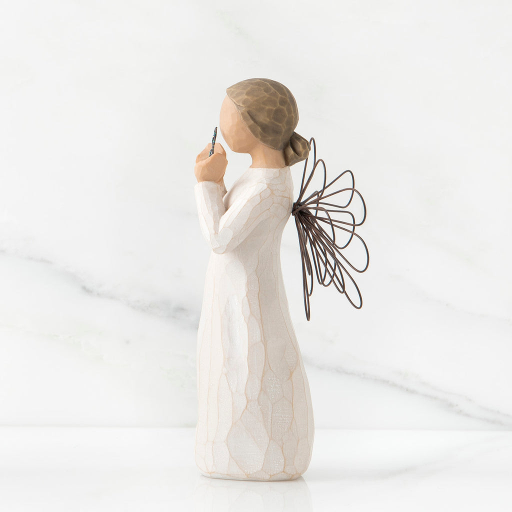 Side view of young brunette girl figurine in white dress with brown wire wings standing