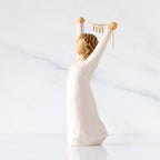 Willow Tree Courage 2025, 6”h hand-painted standing figure in cream dress holding aloft a gold chain with 2025 etched on gold medallions