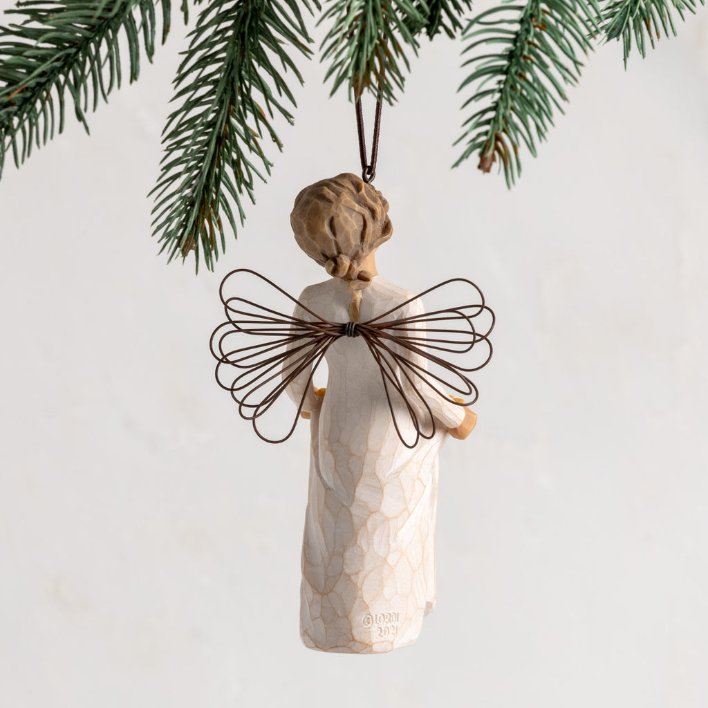 Back view: female figure with wire wings, holding skirt filled with yellow sunflowers; hook and loop affixed to head