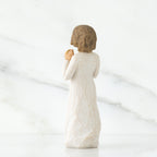 Back view of brunette girl figurine in white dress