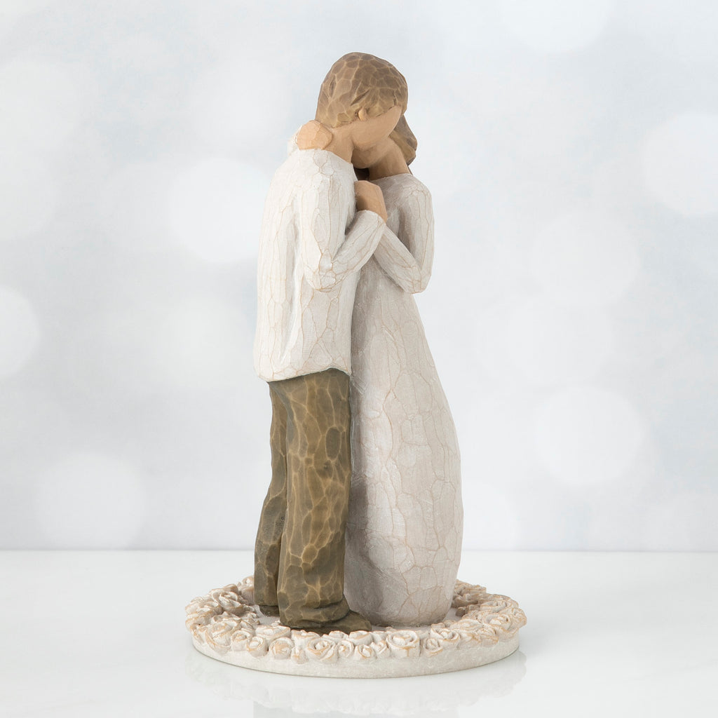 Man and woman figurine standing hugging another on round cream rose plaque