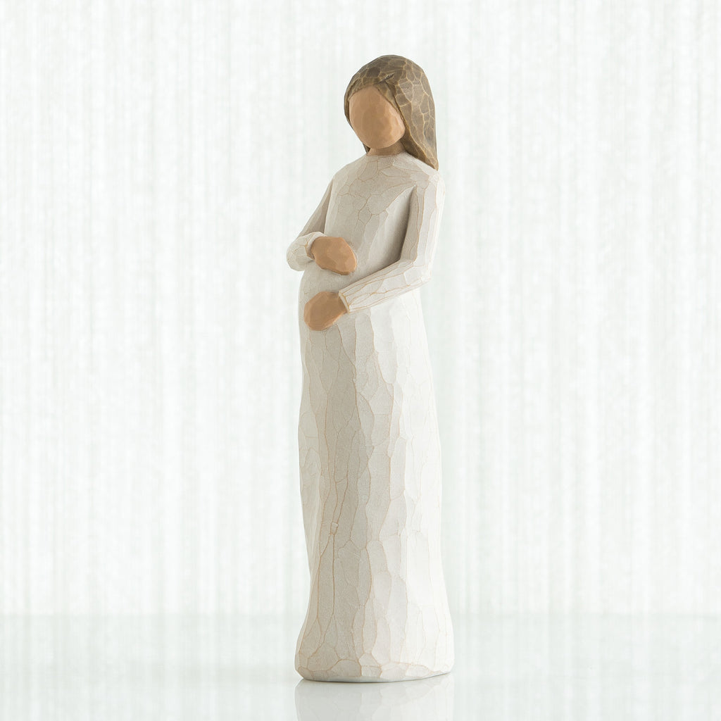 Brunette woman figurine in white holding her stomach facing forward