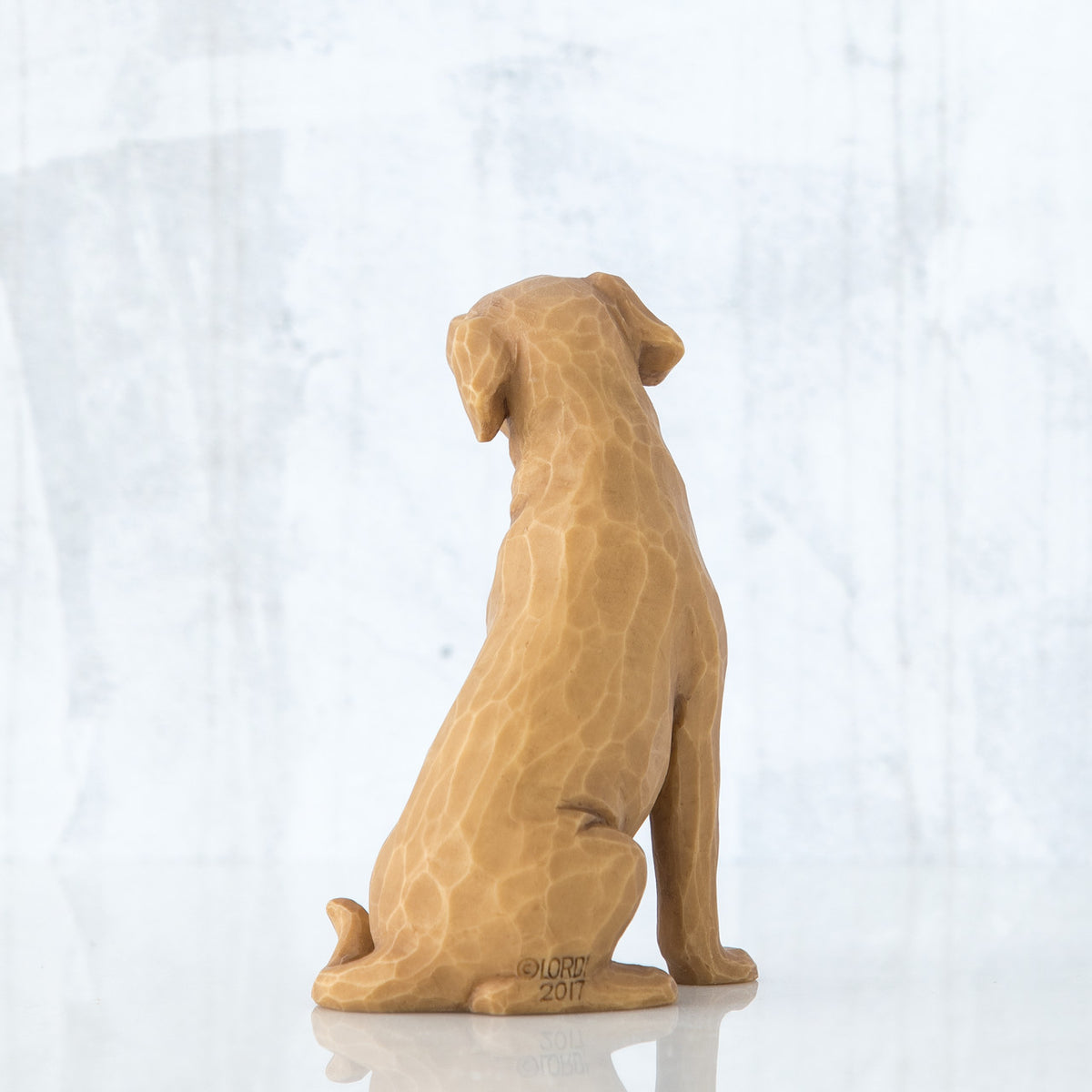 Golden dog figurine sitting - back view