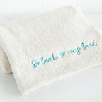 Close view of white towel with 'so loved, so very loved' in light blue