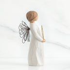 Left side view of angel with short, light brown hair holding a metallic wreath of hearts with both hands