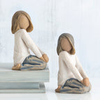 Set of two young girl figurines kneeling in white shirts and blue bottoms