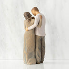 Back view of standing couple, woman has darker skin and hair; man has lighter skin and hair, holding a baby between them.