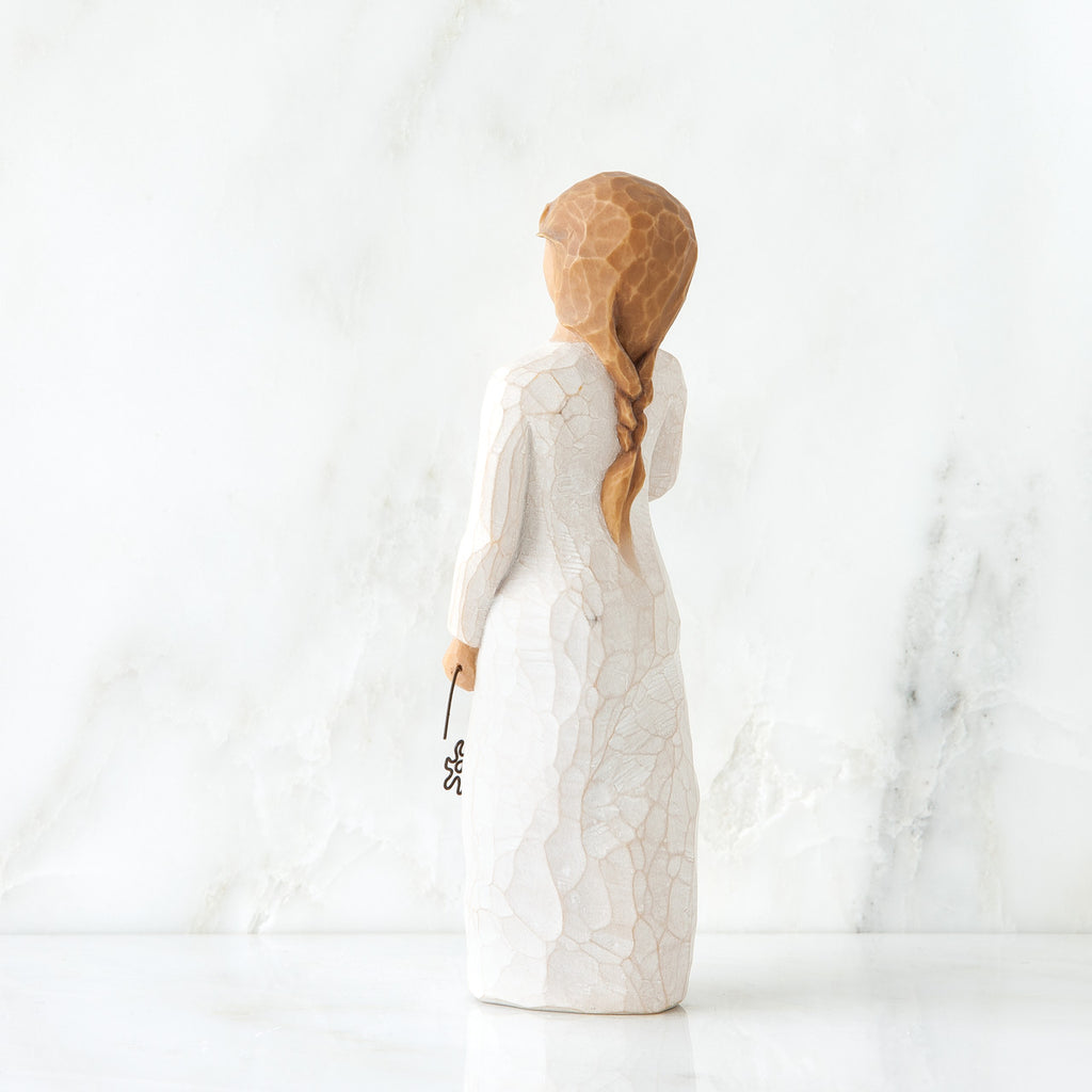 Back view girl figurine in white dress with long red braid