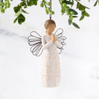 Female figure with wire wings in cream dress carved with a tree design, holding hands in prayer, ornament loop attached to head