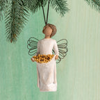 Front view: female figure with wire wings, holding skirt filled with yellow sunflowers; hook and loop affixed to head
