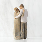 Back view of standing couple, woman has lighter skin and hair; man has darker skin and hair, holding a baby between them.