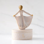 Back view: oval resin box, showing back of 3-D figure in cream dress atop lid