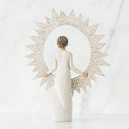 Back view of brunette girl figurine in white dress holding sun figurine up