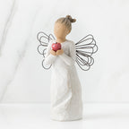 Front view of angel with brown hair in high pony tail leaning forward and holding a red apple up to her face with both hands