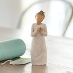 Willow Tree Nurture, 5.5”h hand-painted standing resin figure in cream dress, holding baby bluebird, on table near window
