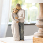 Willow Tree Home, 8.5”h hand-painted standing figure of man and pregnant woman embracing, both in neutral clothes, on table near window