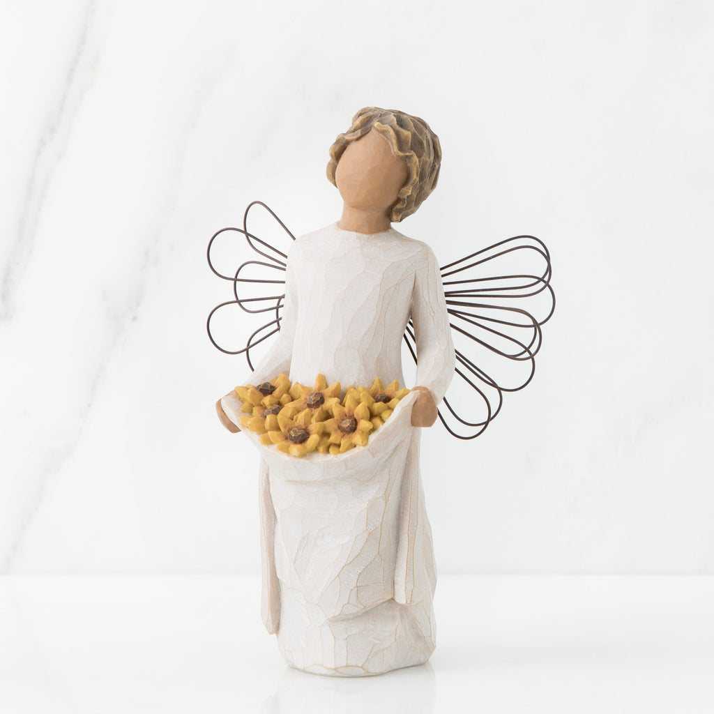 Front view of angel with tied back, curly, dark brown hair holding up a portion of her dress's skirt as it is full of sunflowers