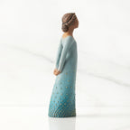Right profile: Darker-skin figure, arms clasped behind back, hair and deep blue ombré garment dotted with gold leaf