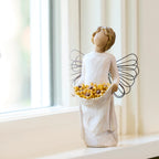 Willow Tree Sunshine, 5.5”h hand-painted standing resin angel with darker skin and hair, cream dress and wire wings, holding up skirt full of Black-Eyed Susans, on windowsill