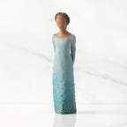 Facing front: Darker-skin figure, arms clasped behind back, hair and deep blue ombré garment dotted with gold leaf