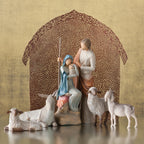 Mary and joesph figurines holding baby with four sheep figurines around them - brown sheer barn paper behind them